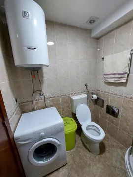 Smaller bathroom with sanitary facilities, washing machine, and water heater. - image 10