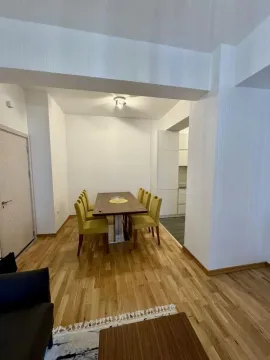 Trpezarija sa drvenim stolom i žutim stolicama u sklopu dnevnog boravka. - image 2