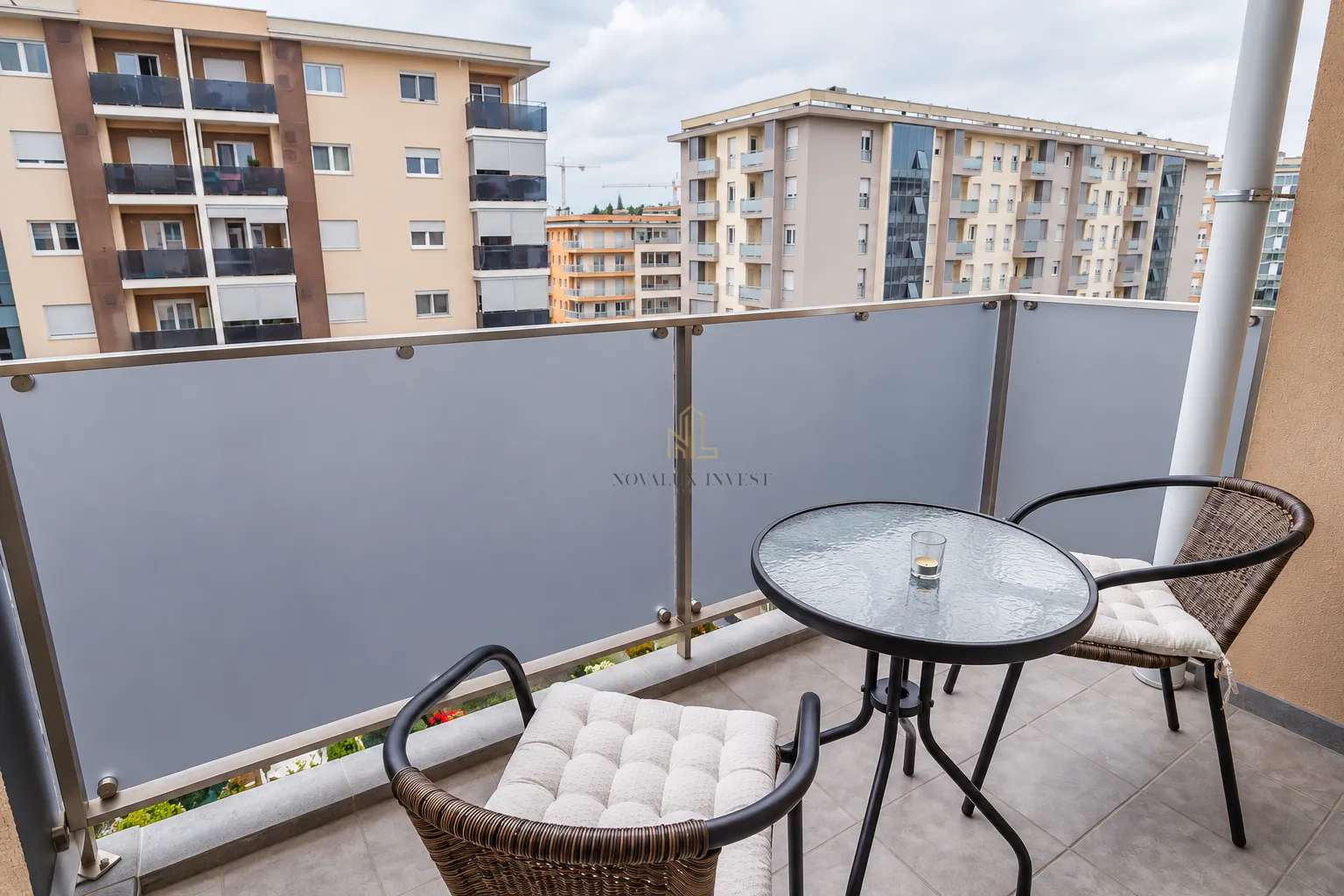 Furnished balcony with a table and chairs and a view of the neighborhood.