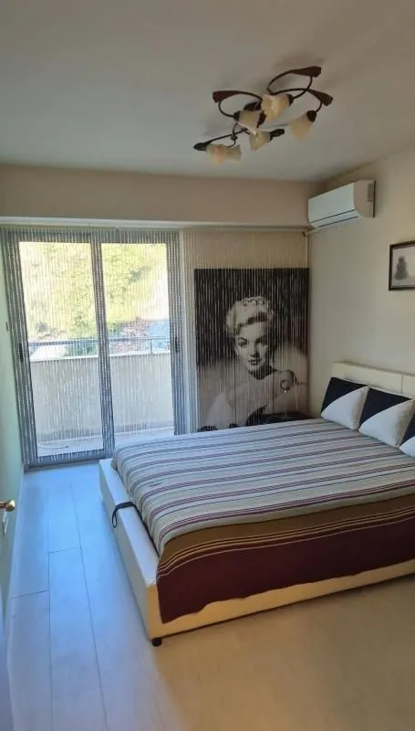 Spavaća soba sa bračnim krevetom, klima uređajem i izlazom na terasu.