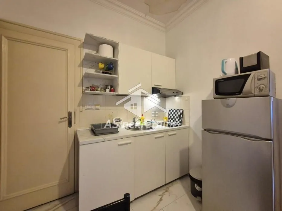 Smaller kitchen with white cabinetry, a refrigerator, and a microwave.