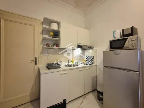 Smaller kitchen with white cabinetry, a refrigerator, and a microwave. - image 8