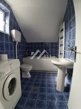 Kupatilo obloženo plavim pločicama sa kadom, toaletom, umivaonikom i mašinom za veš. - image 10