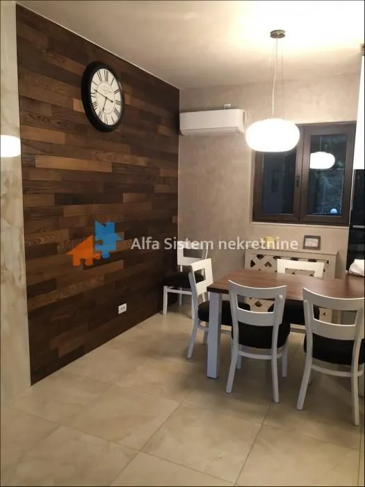 Dining area with wooden wall paneling and a dining table with chairs.