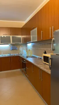 Opremljena kuhinja sa drvenim elementima i radnom površinom. - image 7