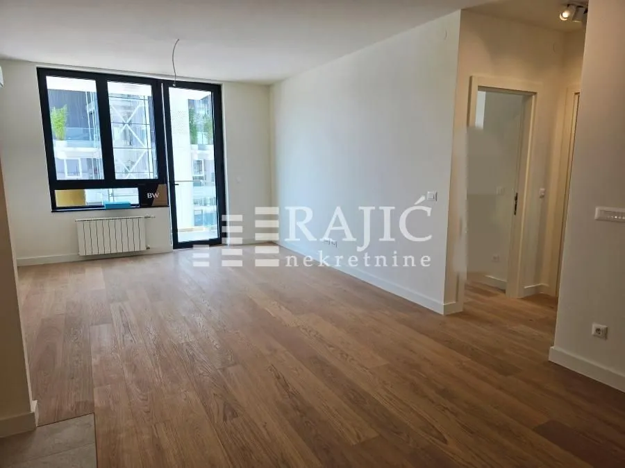 Empty living room with parquet flooring and access to the terrace.