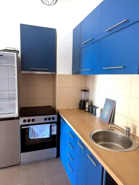 Small kitchen with blue cabinets and a stove. - image 6