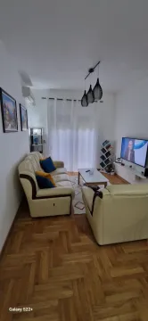 Living room with a sofa set, coffee table, and television. - image 3