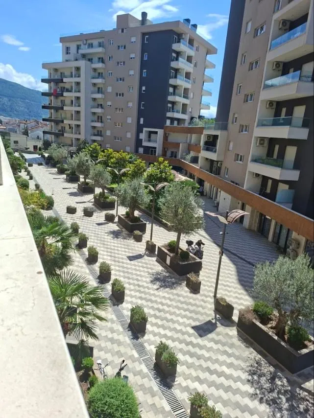 View from the terrace onto the paved courtyard between residential buildings.