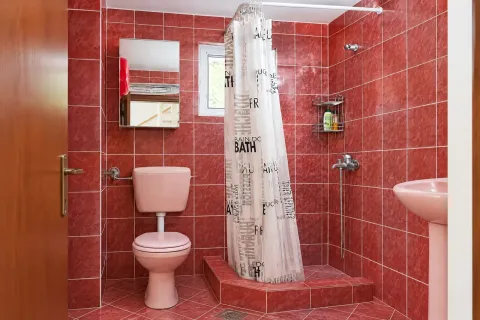 Kupatilo sa crvenim keramičkim pločicama i roze sanitarijama. - image 17