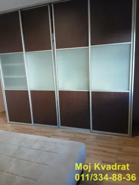 Bedroom with a large built-in sliding door wardrobe and a double bed. - image 9