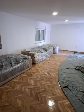 Prazna prostorija sa parketom i nameštajem prekrivenim zaštitnom folijom. - image 4