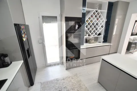 Modern kitchen with built-in oven, refrigerator, and wine rack. - image 12