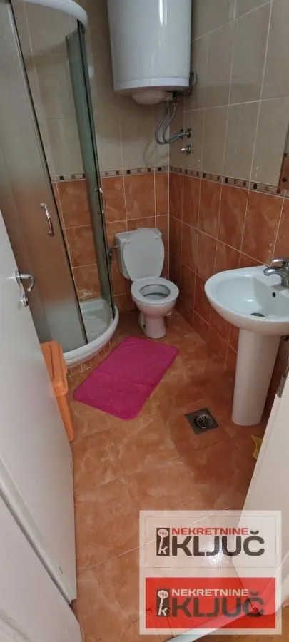 Manje kupatilo sa tuš kabinom, WC šoljom i umivaonikom.