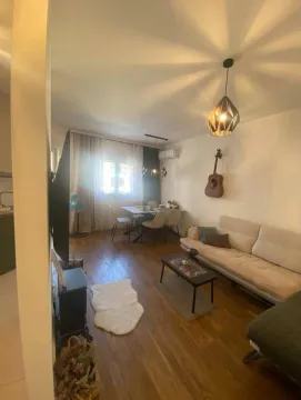 Dnevna soba sa garniturom, stočićem i trpezarijskim stolom u uglu. - image 4