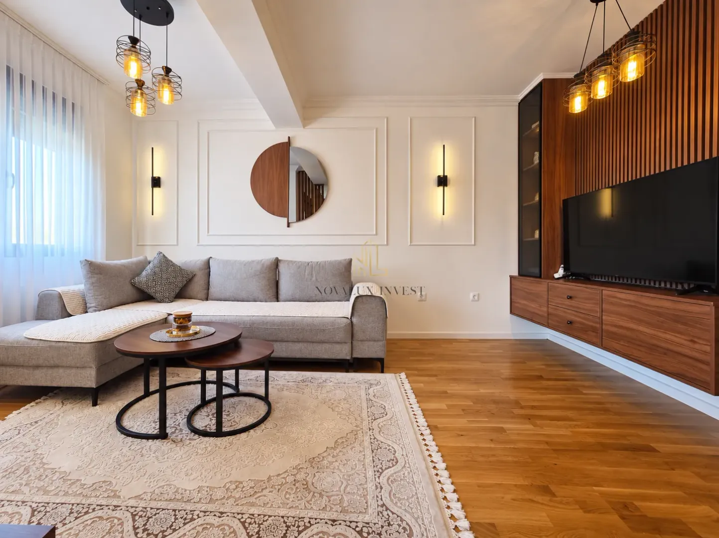 Modern living room with a sectional sofa, wooden furniture, and decorative lighting.