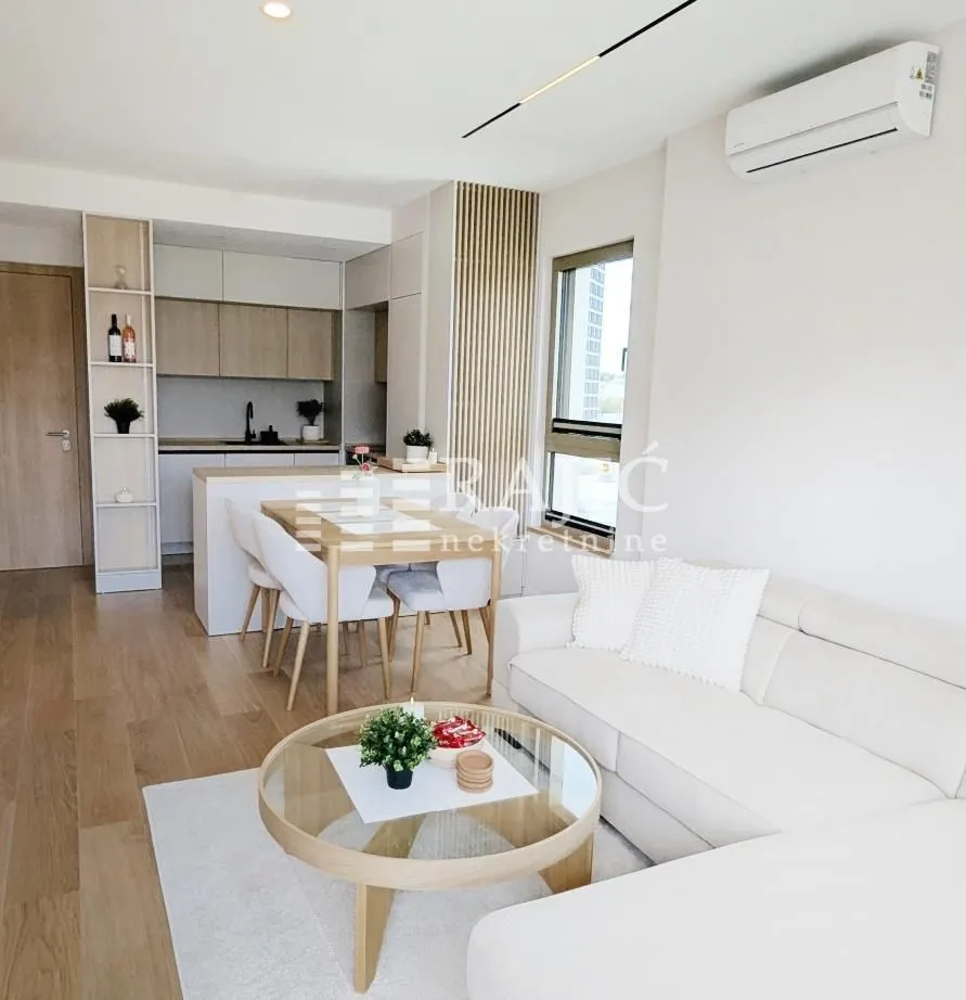 Living room with dining area and kitchen in bright tones.