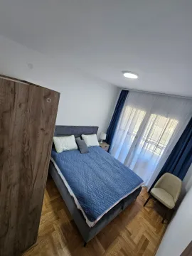 Uređena spavaća soba sa bračnim krevetom, plakarom i izlazom na terasu. - image 8