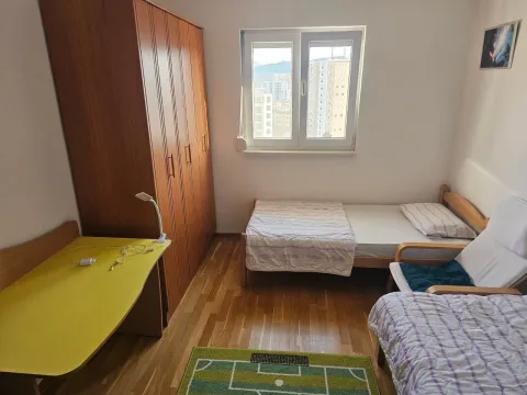 Furnished bedroom with a bed, wardrobe, and desk. - image 6