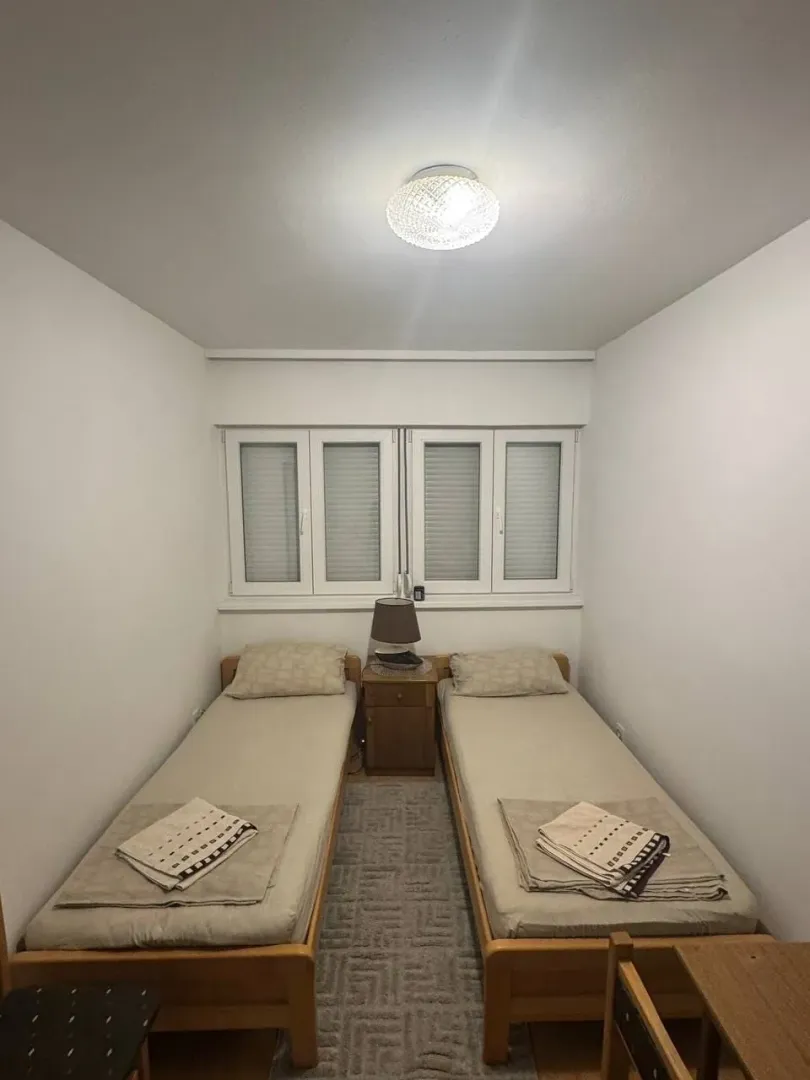 Small bedroom with two single beds and a window.