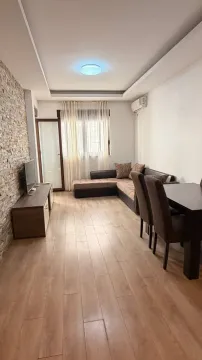 Living room with sofa, TV unit, and dining table. - image 3
