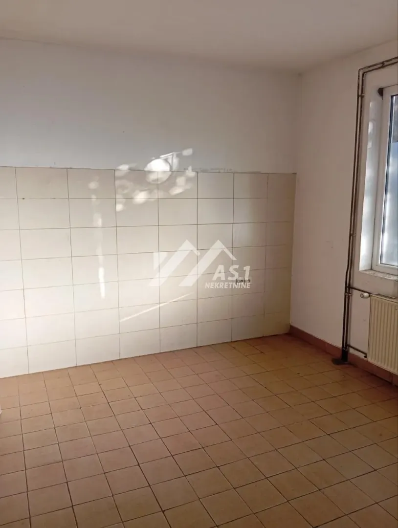 Empty kitchen with wall and floor tiles.