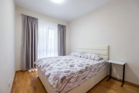 Bright bedroom with a double bed and a window with curtains. - image 6