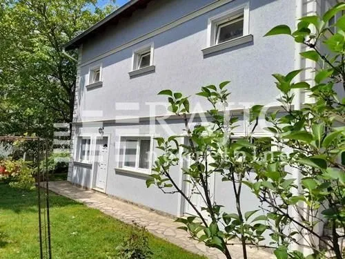 Exterior view of the house with a yard and walkway.
