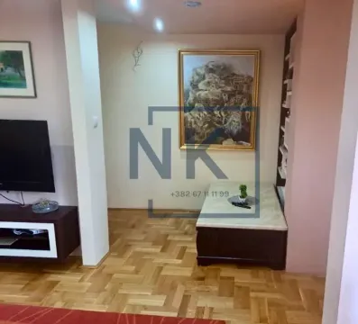 Dnevna soba sa TV-om, slikama na zidu i parketom. - image 4