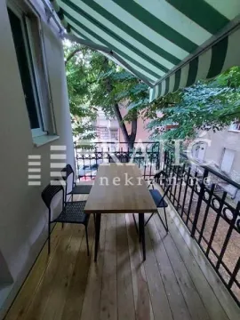 Covered terrace with a wooden table and chairs. - image 12