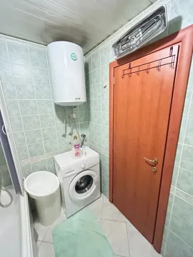 Manje kupatilo sa kadom, bojlerom, veš mašinom i drvenim vratima. - image 17
