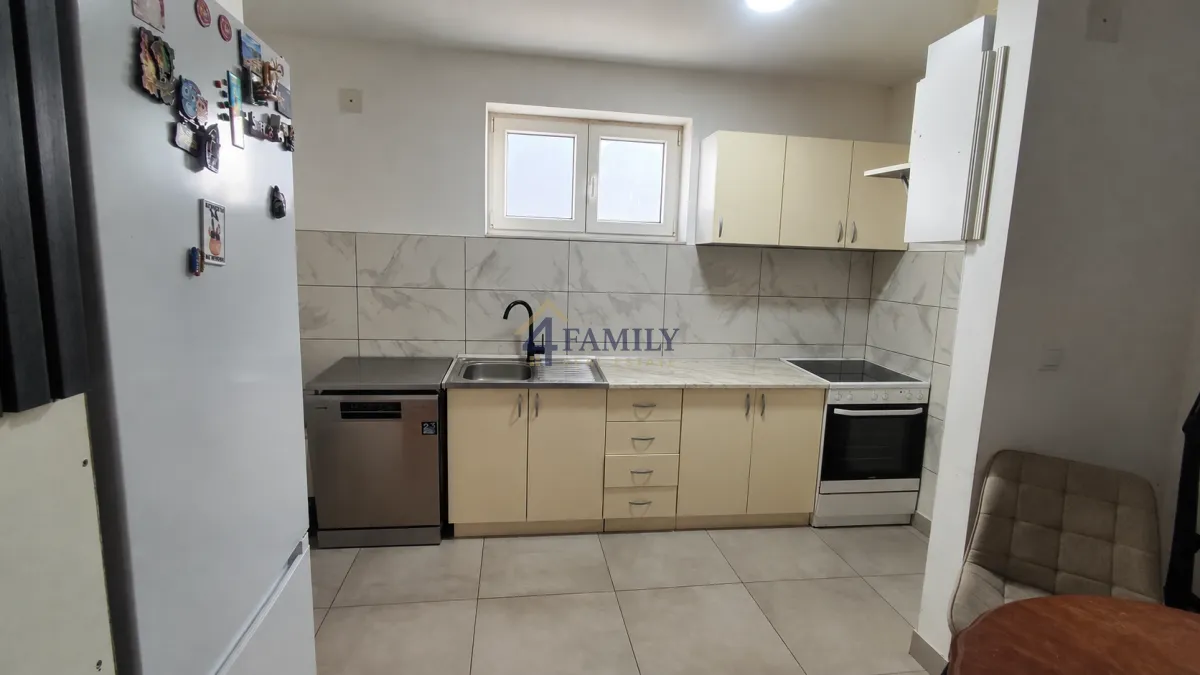 Small kitchen with light cabinets and built-in appliances.