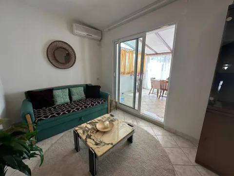 Living room with a green sofa, coffee table, and access to the enclosed terrace. - image 5