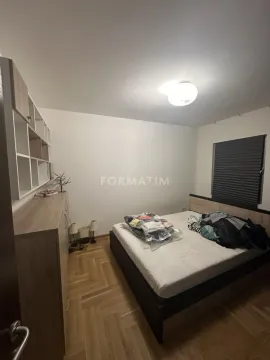 Bedroom with a double bed, wooden parquet flooring, and a dresser with shelving. - image 7