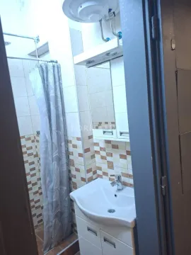View of the bathroom with a washbasin, mirror, and shower with a curtain. - image 7