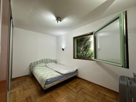 Bedroom with a double bed, parquet flooring, and an open window. - image 2