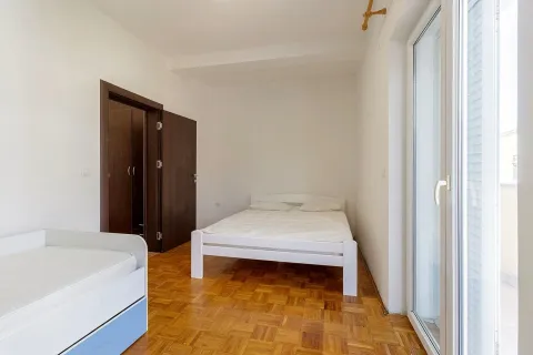 Spavaća soba sa bijelim krevetima, drvenim parketom i izlazom na terasu. - image 9