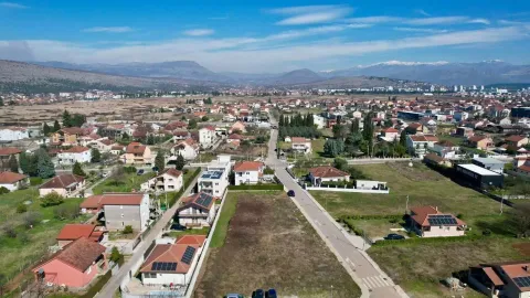 Pogled iz vazduha na prigradsko naselje sa planinama u pozadini. - image 3