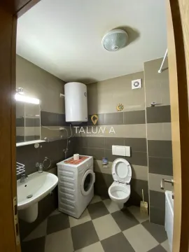 Bathroom equipped with a washbasin, washing machine, toilet, and water heater. - image 3