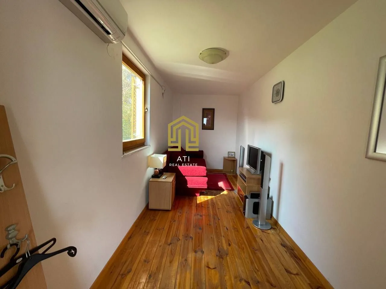 Living room with wooden flooring and a window.