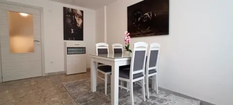 Dining room with a white table, chairs, and artwork on the wall. - image 11