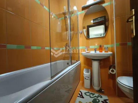 Kupatilo sa kadom, umivaonikom i toaletom u narandžastim tonovima. - image 10
