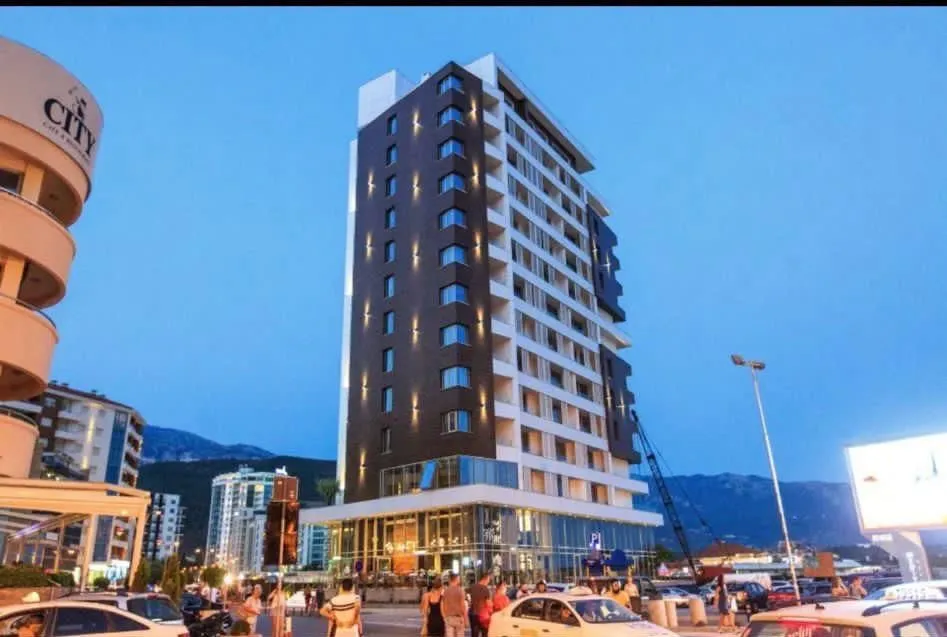 Exterior view of a modern multi-story residential building in the evening.
