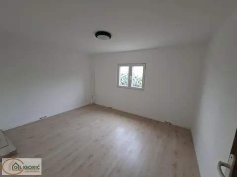 Prazna soba sa belim zidovima, laminatom na podu i jednim prozorom. - image 11