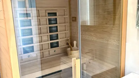 Wooden sauna with glass door and benches. - image 10