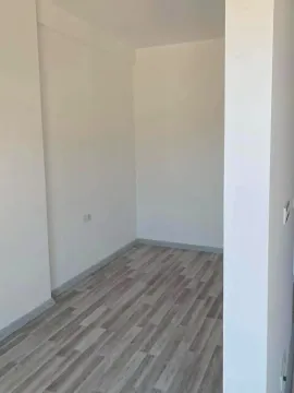 Prazna soba sa bijelim zidovima i laminatnim podom. - image 6