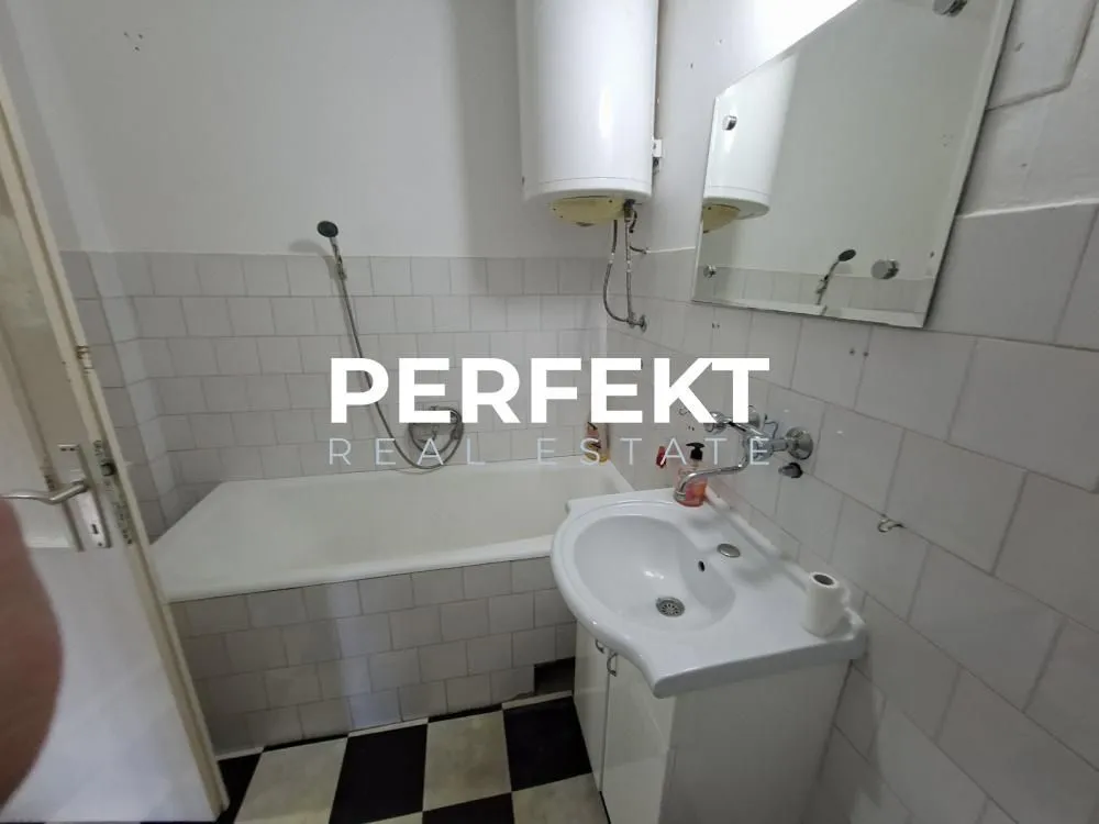Manje kupatilo sa kadom, umivaonikom i ogledalom.