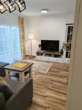 Uređena dnevna soba sa garniturom, TV komodom i trpezarijskim delom. - image 4