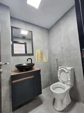 Modernly equipped bathroom with grey tiles, a vanity sink, and a toilet. - image 14