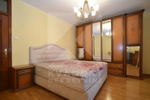 Bedroom with a double bed, large wooden wardrobe, and bedside table. - image 9